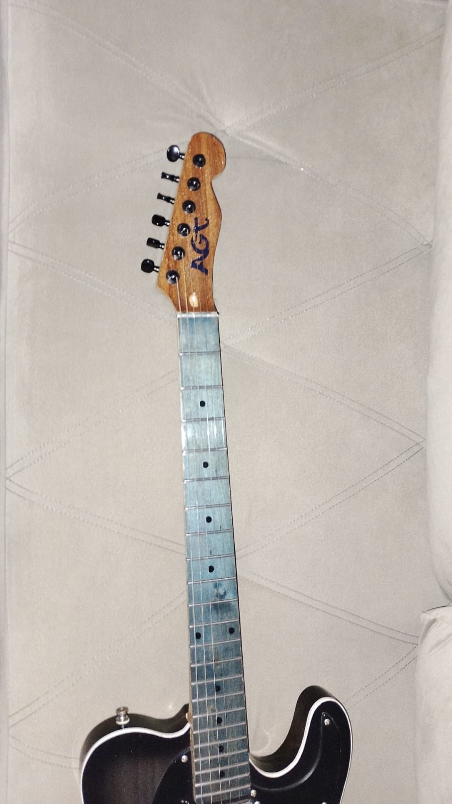 Detalhe da escala azulada, dos trastes e do headstock com o logo AGT e tarraxas pretas